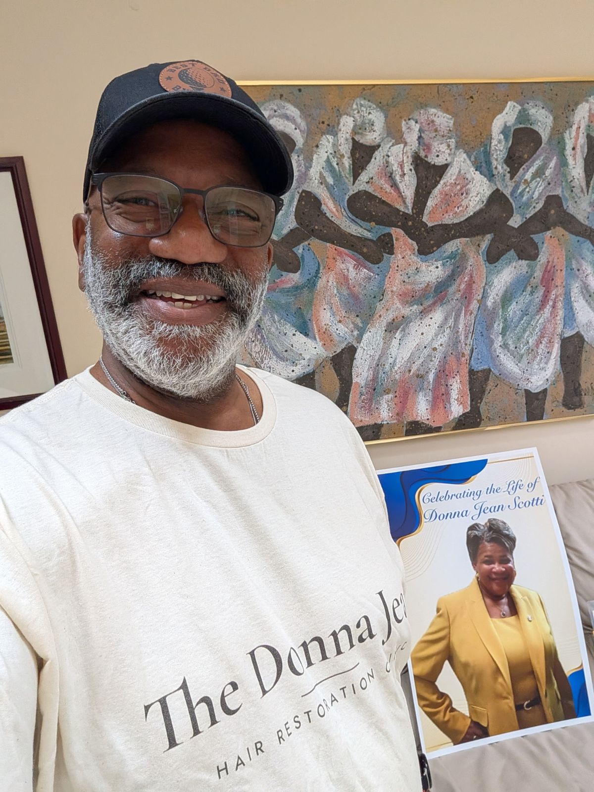 Victor’s father in a Donna Jean Clinic shirt beside her Celebration of Life sign